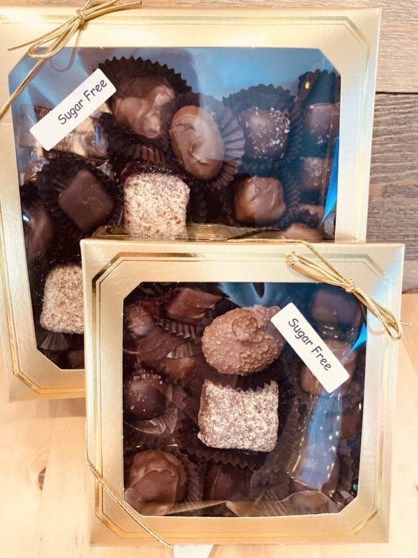A variety of chocolates in a gold box with a sugar free sticker on top